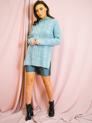 Sube el jersey de punto de cable de dobladillo con capucha